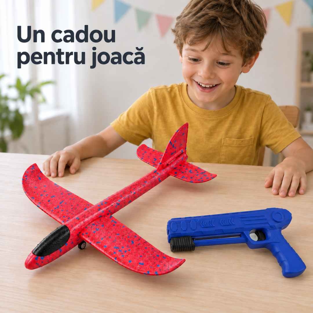 Copil la masă cu avionul asamblat și lansatorul alături, prezentate ca idee de cadou