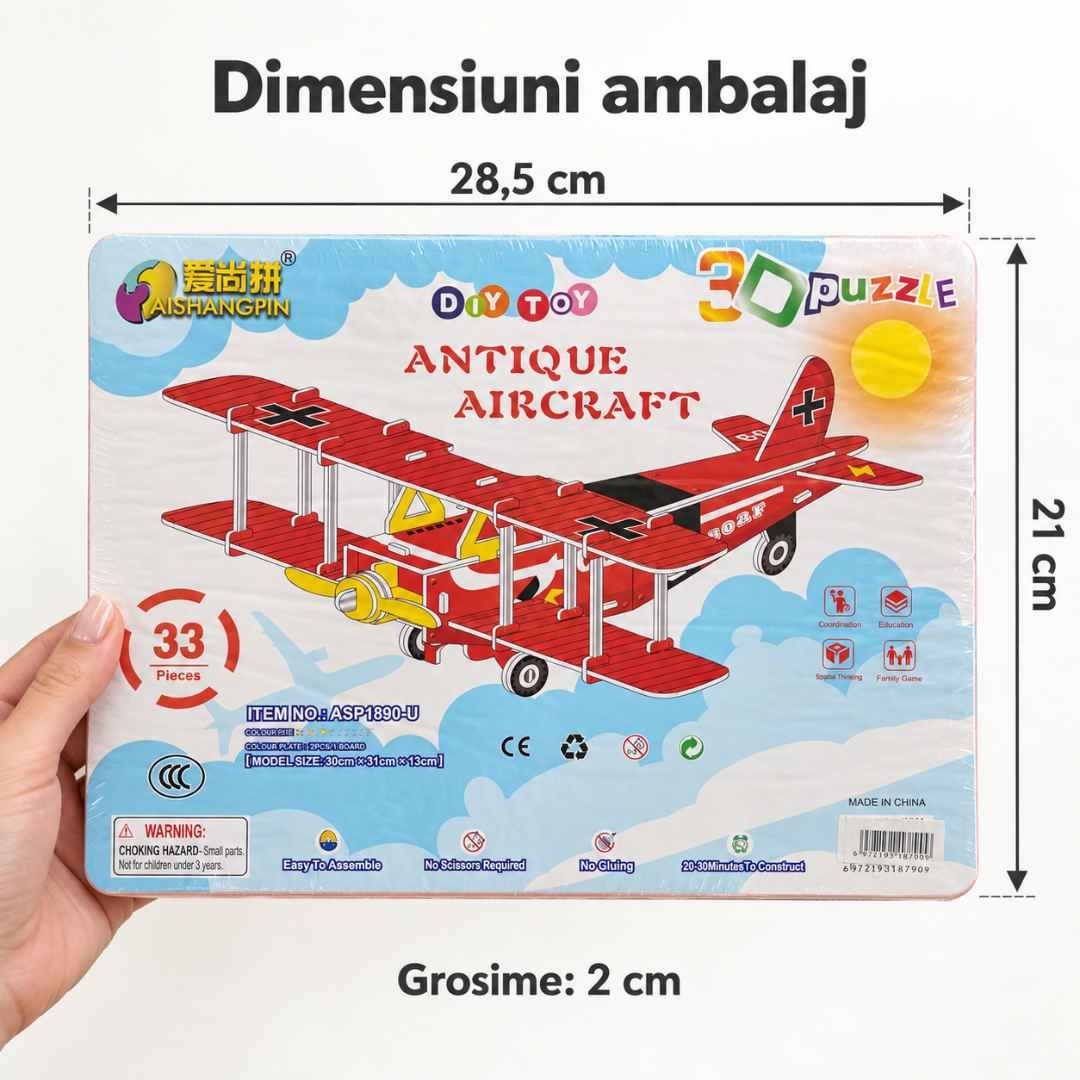 Ambalajul puzzle-ului de avion ținut într-o mână, cu dimensiunile de 28,5 × 21 × 2 cm