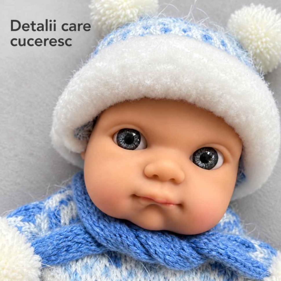 Prim-plan cu fața realistă, ochii și căciulița păpușii bebeluș