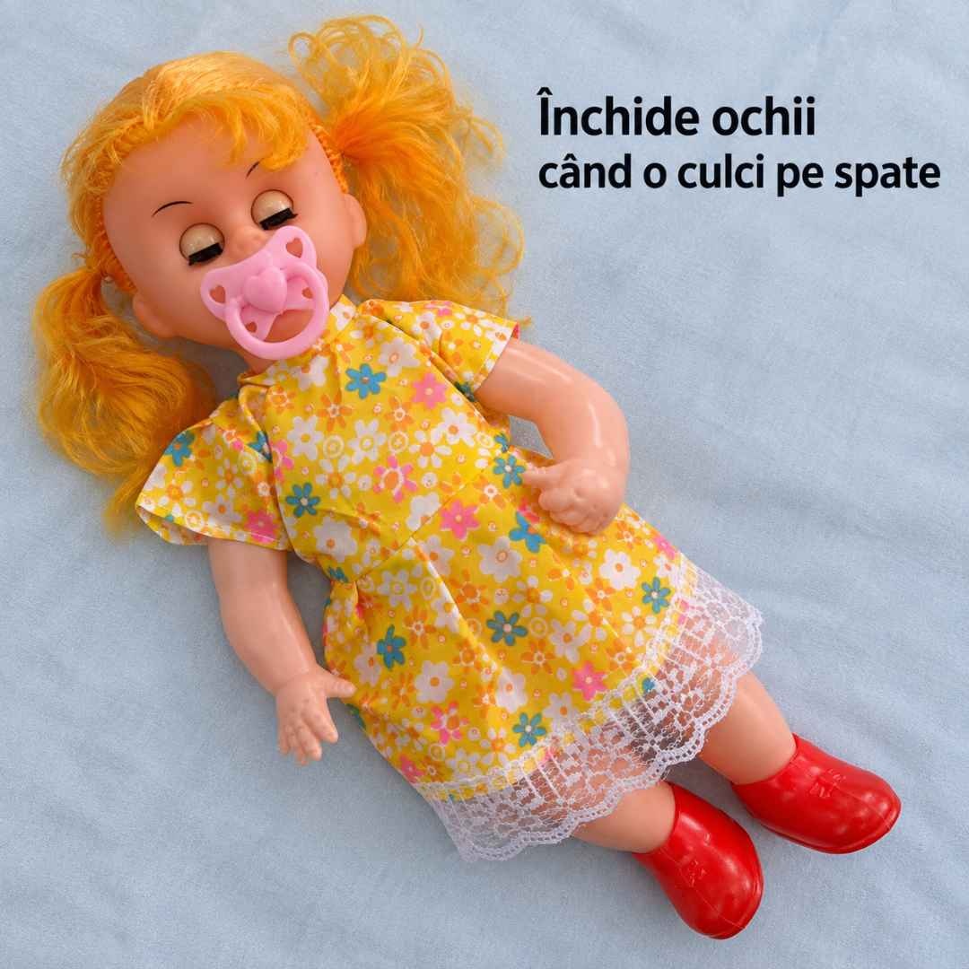 Păpușa culcată pe spate, cu ochii închiși și suzeta în gură