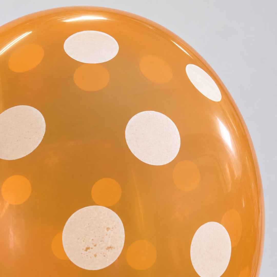 Detaliu al bulinelor albe de pe suprafața unui balon portocaliu umflat