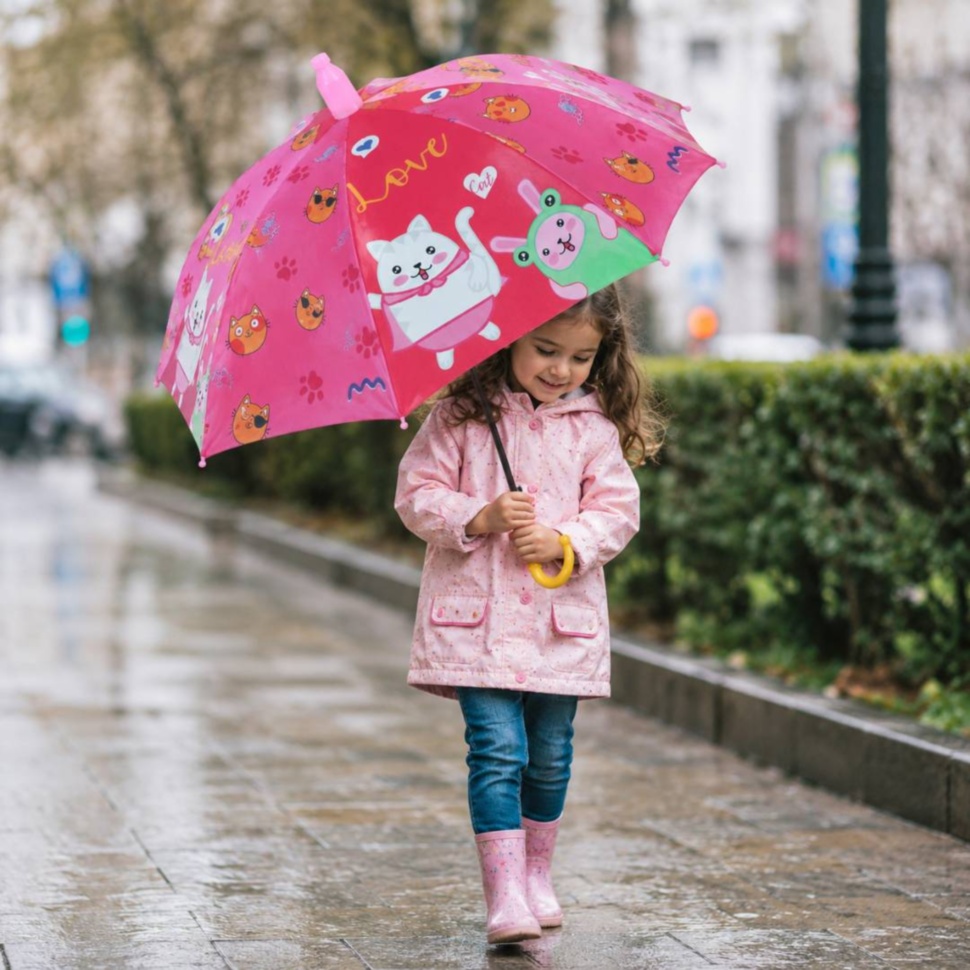 Copil merge prin ploaie cu umbrelă roz cu pisicuțe