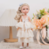 Păpușă Sennby Baby cu Rochie Alb-Crem și Accesoriu Elegant – 35 cm